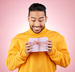 Man, winner and excited for gift box, prize and giveaway celebration or birthday surprise on pink background. Happy person with present, package and retail shopping or competition success in studio