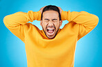 Angry, man and face with screaming in studio with burnout, anxiety and stress. Isolated, blue background and frustrated male person with yelling and mental health problem from mistake and issue