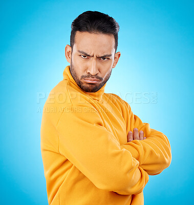 Buy stock photo Portrait, frown and asian man with arms crossed in studio angry, frustrated and annoyed on blue background. Conflict, anger and face of Japanese male with defensive body language, denial or offended