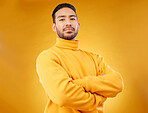Fashion, winter and portrait of man with arms crossed for style, cool and trendy aesthetic. Serious, handsome and Asian person or model with confidence, pride and fashionable on a studio background