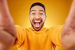 Excited, portrait and selfie of happy man in studio isolated on a yellow background. Face, smile and Asian person taking profile picture for funny memory, laughing and photography on social media