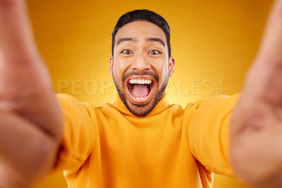 Buy stock photo Excited, portrait and selfie of happy man in studio isolated on a yellow background. Face, smile and Asian person taking profile picture for funny memory, laughing and photography on social media