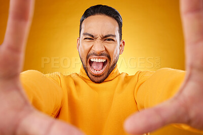 Buy stock photo Shouting, portrait and selfie of angry man in studio isolated on a yellow background. Face, screaming and Asian person taking profile picture for memory in anger, frustrated or stress on social media