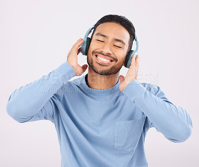 Buy stock photo Headphones, music and man dancing with energy in a studio with album or playlist with technology. Happy, smile and Indian young male person doing a dance to song or radio isolated by white background