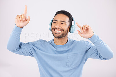 Buy stock photo Headphones, energy and man doing a dance in a studio with music, album or playlist with technology. Happy, smile and Indian young male model dancing to song or radio isolated by a white background.