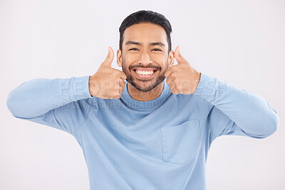 Buy stock photo Portrait, thumbs up and man in studio happy with hand, sign and thank you on white background. Smile, face and Mexican person with emoji for yes, vote or positive review, like feedback or agree