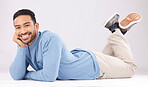 Portrait, happy or Asian man lying on floor isolated on a white background in studio to relax. Friendly smile, calm person or proud male model resting with confidence, fashion or style on the ground 