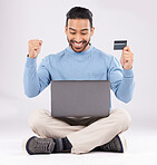 Celebration, laptop and asian man with credit card in studio excited for cashback bonus on grey background. Online shopping, giveaway and male customer with good news, membership or sign up success