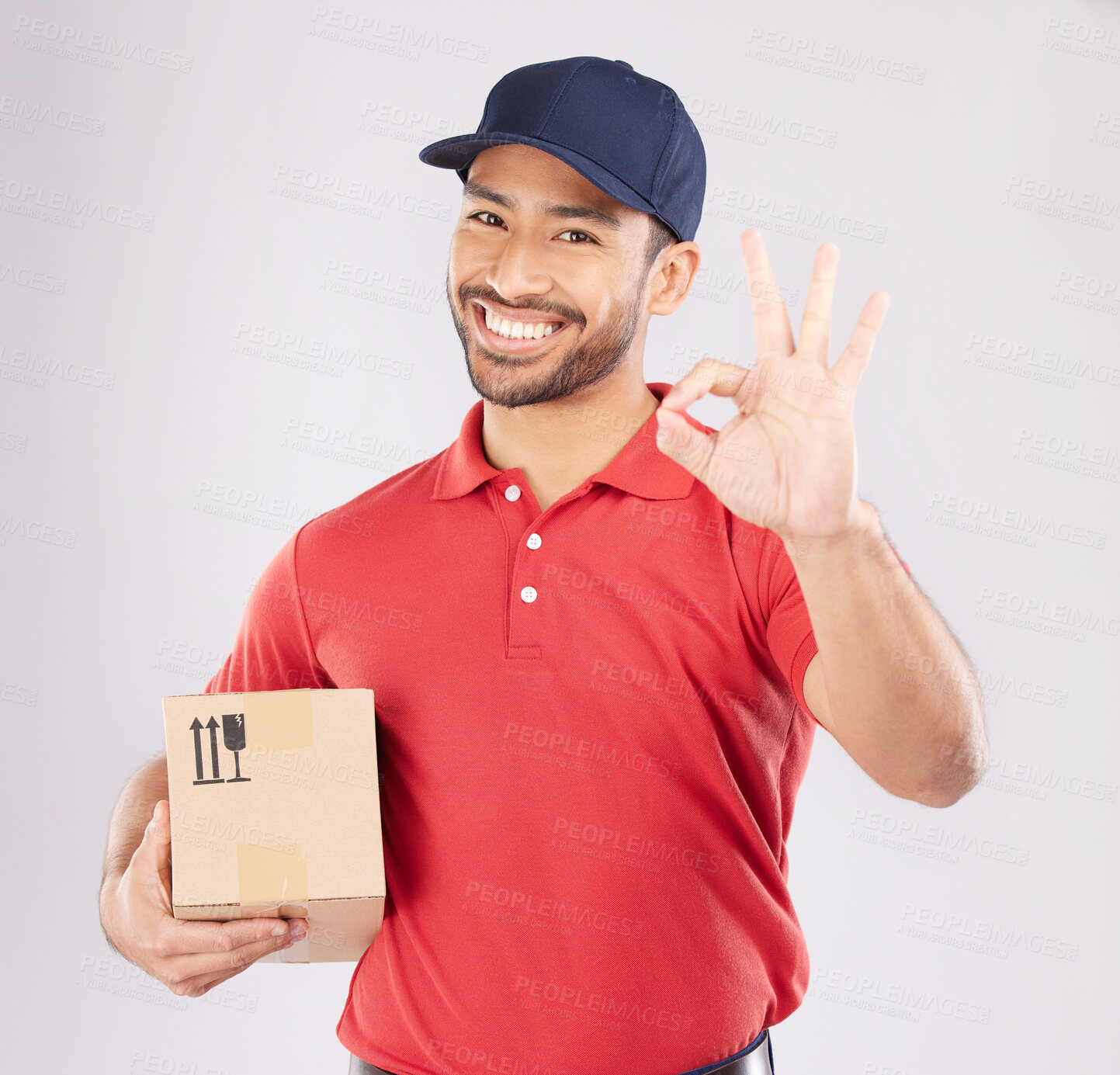 Buy stock photo Courier man, ok sign and studio portrait with box, delivery, opinion or good service by white background. Supply chain manager, happy or review with like icon, emoji and hand with cardboard package