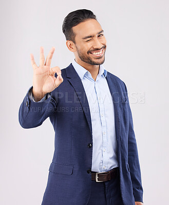 Buy stock photo Wink, portrait and asian man with perfect hand sign for support, agreement or feedback, thank you or review on grey background. Smile, face and emoji okay gesture by male with approval, like or yes