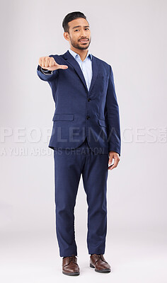 Buy stock photo Neutral review, portrait and businessman in suit on a studio background for marketing or feedback. Choice, sign language and an Asian lawyer with a thumb gesture for a decision isolated on a backdrop