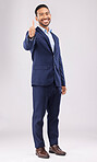Happy businessman, portrait and thumbs up for approval, success or winning against a grey studio background. Asian man smile with like emoji, yes sign or good job for business agreement and thank you