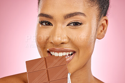 Buy stock photo Woman, chocolate and bite in studio portrait with smile, eating and skin glow for beauty by pink background. Girl, model and diet with sweets, snack or candy for cheat day, cosmetics and headshot