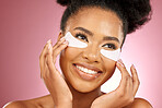 Skincare, face and black woman with mask on eyes, cosmetics and dermatology on pink background. Beauty, collagen product and happy model eye patches for healthy skin glow, smile and care in studio.