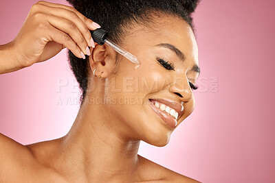 Buy stock photo Happy woman, oil and serum on face, beauty and aesthetic dermatology on pink background in studio. African female model, facial cosmetics and skincare dropper of hyaluronic acid for healthy collagen