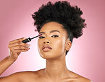 Mascara, makeup and beauty portrait of a woman for skincare, wellness and dermatology glow. Volume, eyelash and face cosmetics of a black female model with facial shine on a pink background in studio