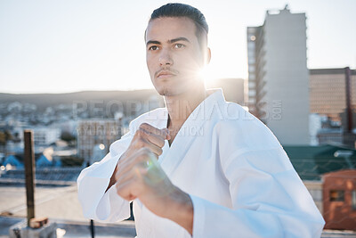 Buy stock photo Karate, fitness and hands with a sports man in the city for self defense training or a combat workout. Exercise, health and fighting with a serious young male athlete or warrior in an urban town