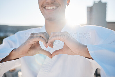 Heart in hands, karate and man in city for training, exercise and sports in morning outdoors. Happy, love emoji and male person with hand gesture for care in town for combat, martial arts and workout