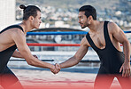 Men, handshake and fight sport in ring, respect or fitness in challenge, battle and gym on roof in cbd. Shaking hands, wrestling coach or friends for contest, exercise or martial arts in Cape Town