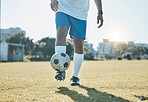 Training, field and legs of a man with a football for a game, fitness and learning sports. Grass, workout and feet of an athlete for a goal, exercise and playing professional soccer in nature