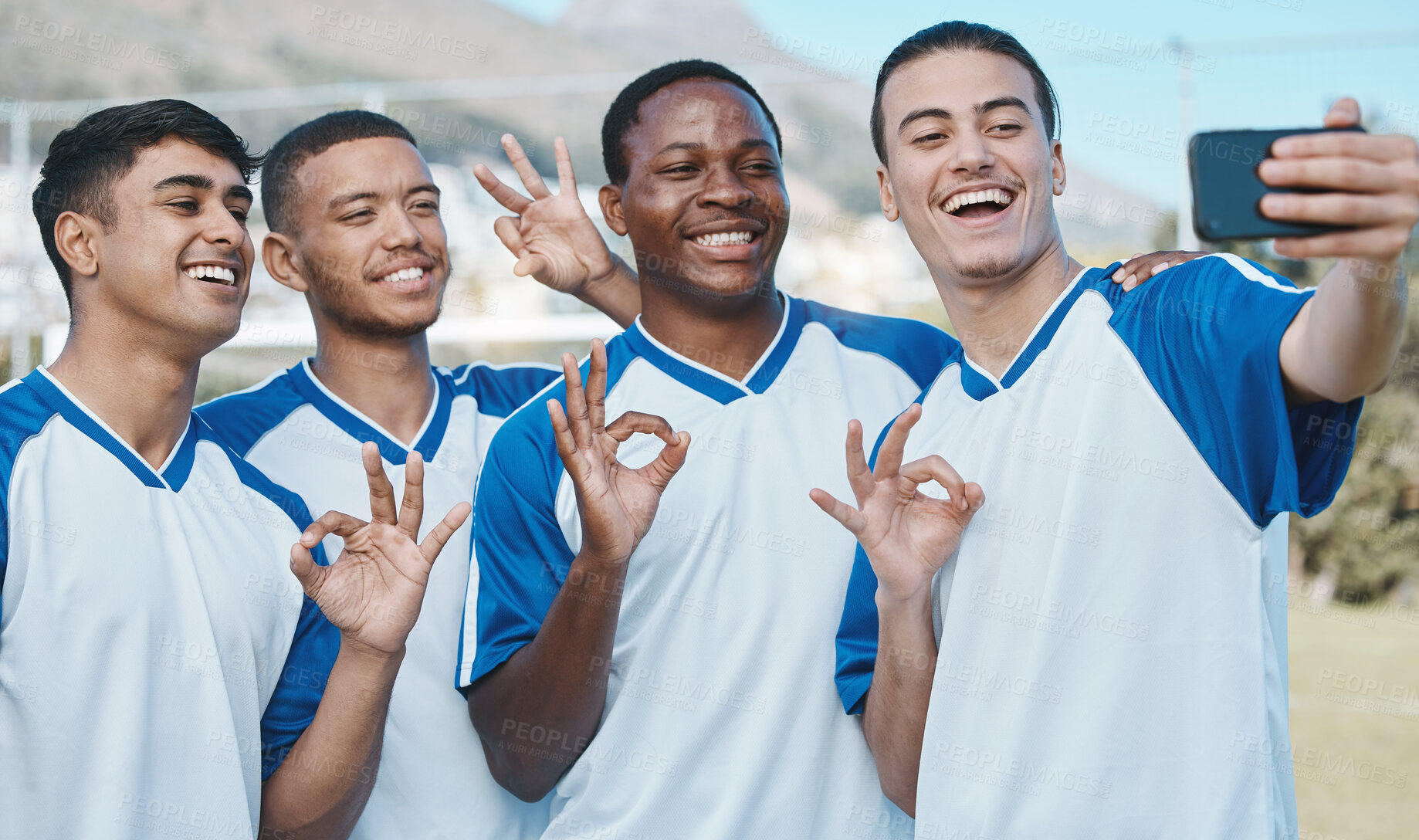 Buy stock photo Men in selfie, OK hand sign and soccer competition, sports and athlete group on field, diversity and emoji. Happy, young male football player and team smile in picture, gesture and social media post