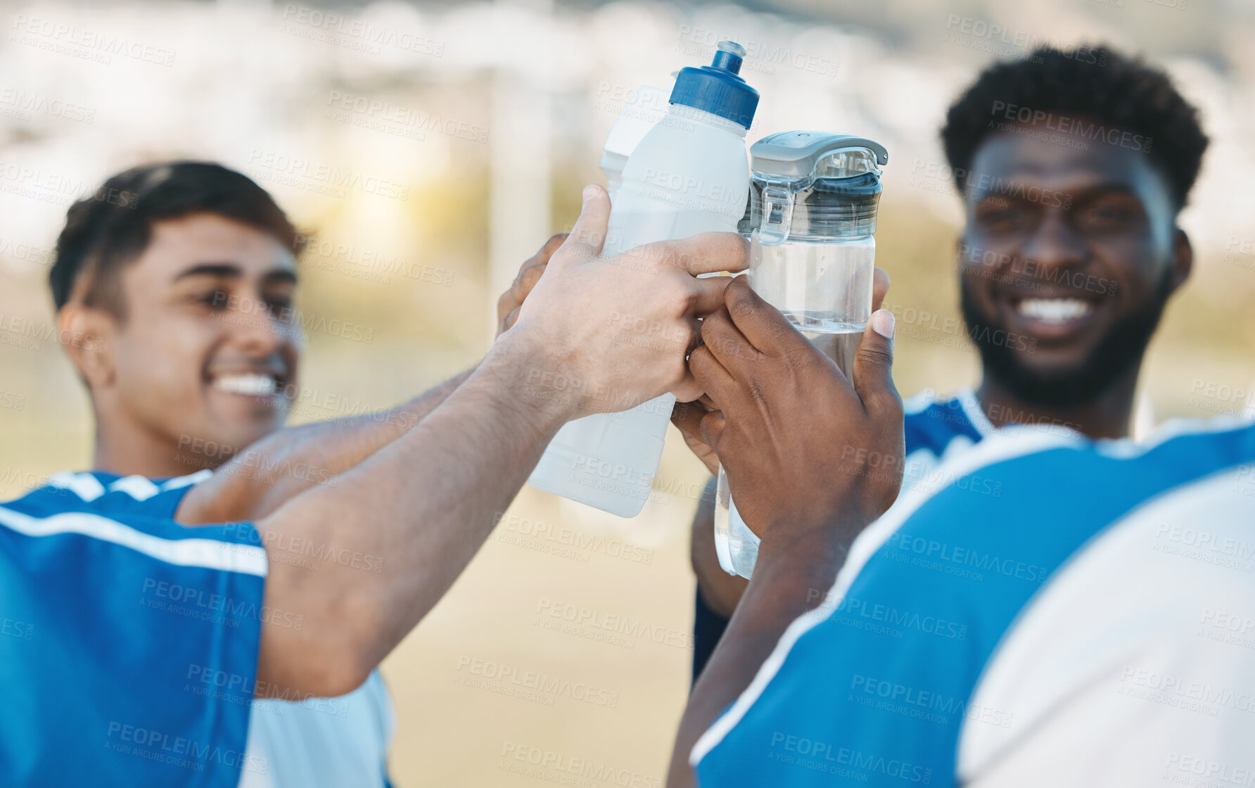 Buy stock photo Success, happy and men in soccer with water bottle after a game, sports win or celebration after training. Smile, drink and athlete people with a toast for achievement, motivation or goal in football