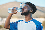 Black man, fitness or soccer player drinking water in training, exercise or workout in football field. Thirsty, sports or tired athlete on resting break with a healthy beverage for energy to relax