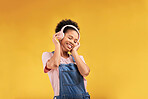 Music, headphones and happy black woman listening in studio isolated on a yellow background mockup space. African person, smile or hearing radio, podcast or sound for jazz, hip hop or streaming audio