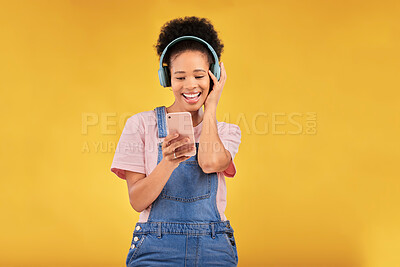Buy stock photo Online, music and a black woman with a phone on a studio background for a podcast or audio. Smile, space and an African girl with headphones and a mobile for an app, streaming and listening to radio
