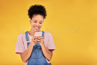 Buy stock photo Smile, typing and woman with phone in studio, texting or social media post with mockup on yellow background. Networking, chat online and happy model with cellphone mobile app, reading meme or email