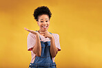 Portrait, marketing and a black woman pointing to her palm for the promotion of a product on a yellow background in studio. Smile, advertising or space with a happy young female brand ambassador