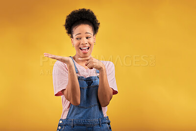 Buy stock photo Branding, advertising and a black woman pointing to her palm for the promotion of a product on a yellow background in studio. Smile, marketing or space with a happy young female brand ambassador