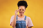 Portrait, glasses and happy with a black woman on a yellow background in studio for vision. Fashion, eyewear and smile with a young afro female nerd at the optometrist for prescription frame lenses