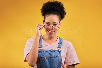 Buy stock photo Portrait, glasses and happy with a black woman on a yellow background in studio for vision. Fashion, eyewear and smile with a young afro female nerd at the optometrist for prescription frame lenses
