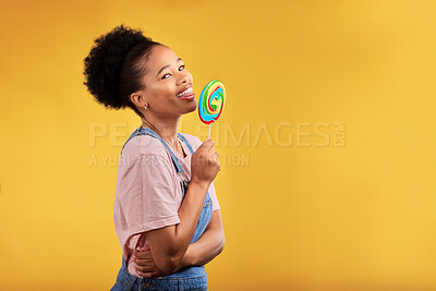 Buy stock photo Black woman, portrait and eating candy or lollipop in studio on yellow background and sweets, dessert or food with sugar. Gen z, girl and guilty pleasure in delicious treats, snack or product