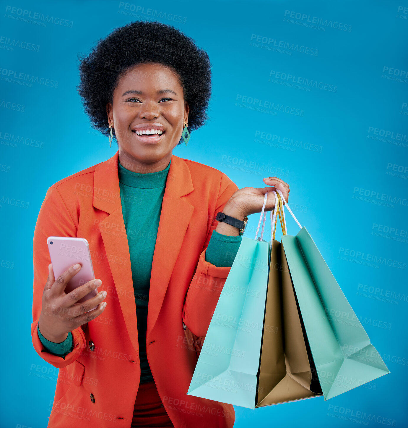 Buy stock photo Shopping bag, phone and happy woman for e commerce sale, discount or social media on blue background. Portrait, mobile blog and fashion of african person, customer or online user with gift in studio