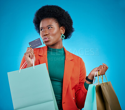 Buy stock photo Credit card, shopping and woman thinking of sales, finance and e commerce fintech or payment choice. Ideas, decision and fashion customer or african person, bag and debit on a blue, studio background