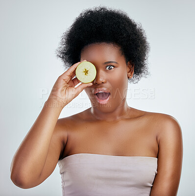 Buy stock photo Skincare, apple and portrait of a woman in studio with a natural, organic and beauty face routine. Shock, wellness and African female model with slice of fruit for facial treatment by gray background