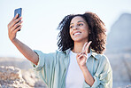 Woman at beach, selfie and peace hand sign, happy with travel and lifestyle influencer, photography and social media. Post, content creation and female person smile in picture outdoor with adventure