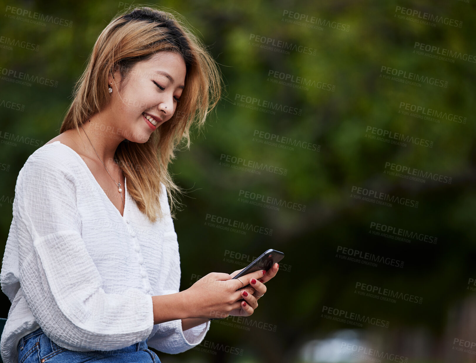 Buy stock photo Happy woman, mockup and typing with phone in garden, reading email, social media meme or text. Cellphone, internet search and Asian girl in park space checking mobile app with smile and chat online.