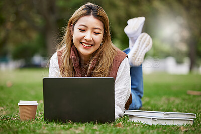 Buy stock photo Laptop, asian and woman student typing in a park to update social media while outdoor studying and learning online. Internet, web and young person working on assessment in nature for peace and calm