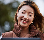 Happy, social media and a woman with a tablet in nature for online communication, app or email. Park, smile and a young Asian girl reading a conversation on technology, website or notification