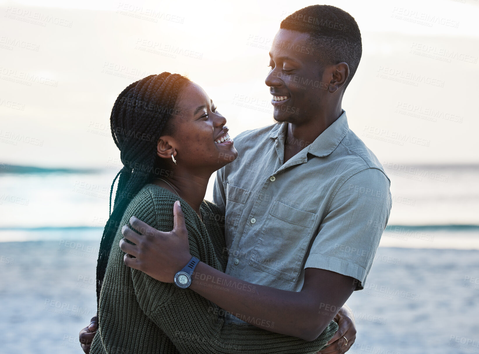 Buy stock photo Black couple, hug and happy outdoor at the beach with love, care and commitment. Smile on face of young african man and woman together on vacation, holiday or sunset travel adventure in Jamaica