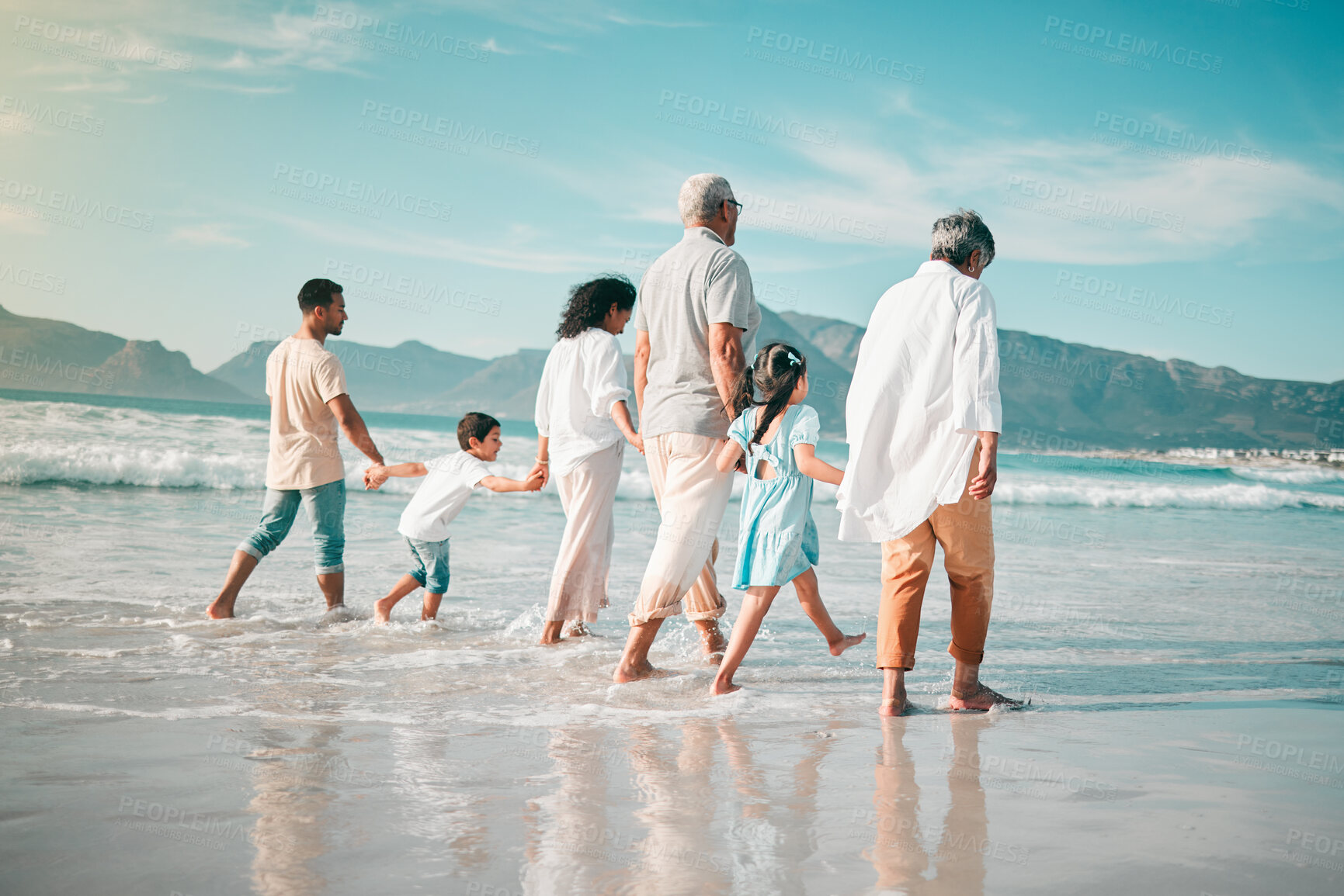 Buy stock photo Holding hands, family is walking on beach with ocean and back view, solidarity and bonding in nature. Generations, people outdoor on tropical holiday and freedom, travel with trust and love in Mexico