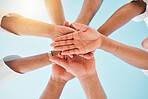 Circle, low angle and team with hands together for collaboration, unity or support by a blue sky. Teamwork, diversity and group of people in an outdoor huddle for motivation, solidarity or community.