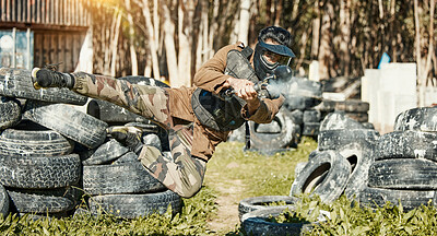 Buy stock photo Paintball, sports and man in action with gun for tournament, competition and battle in nature. Camouflage, military and male person shooting in outdoor arena for training, adventure game or challenge