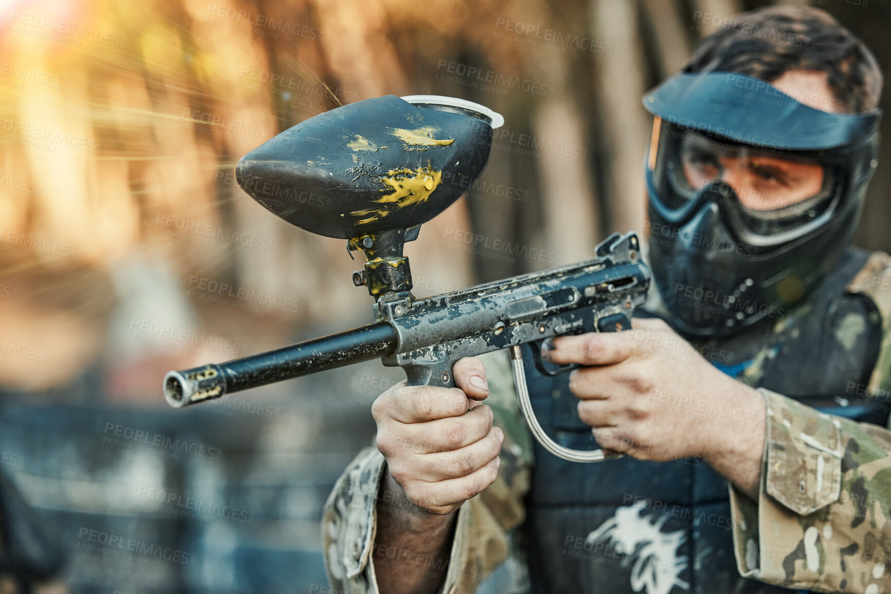 Buy stock photo Paintball, sports and man shooting with gun for tournament, competition and battle in nature. Soldier, military and male person in outdoor arena for training, adventure games and challenge for action