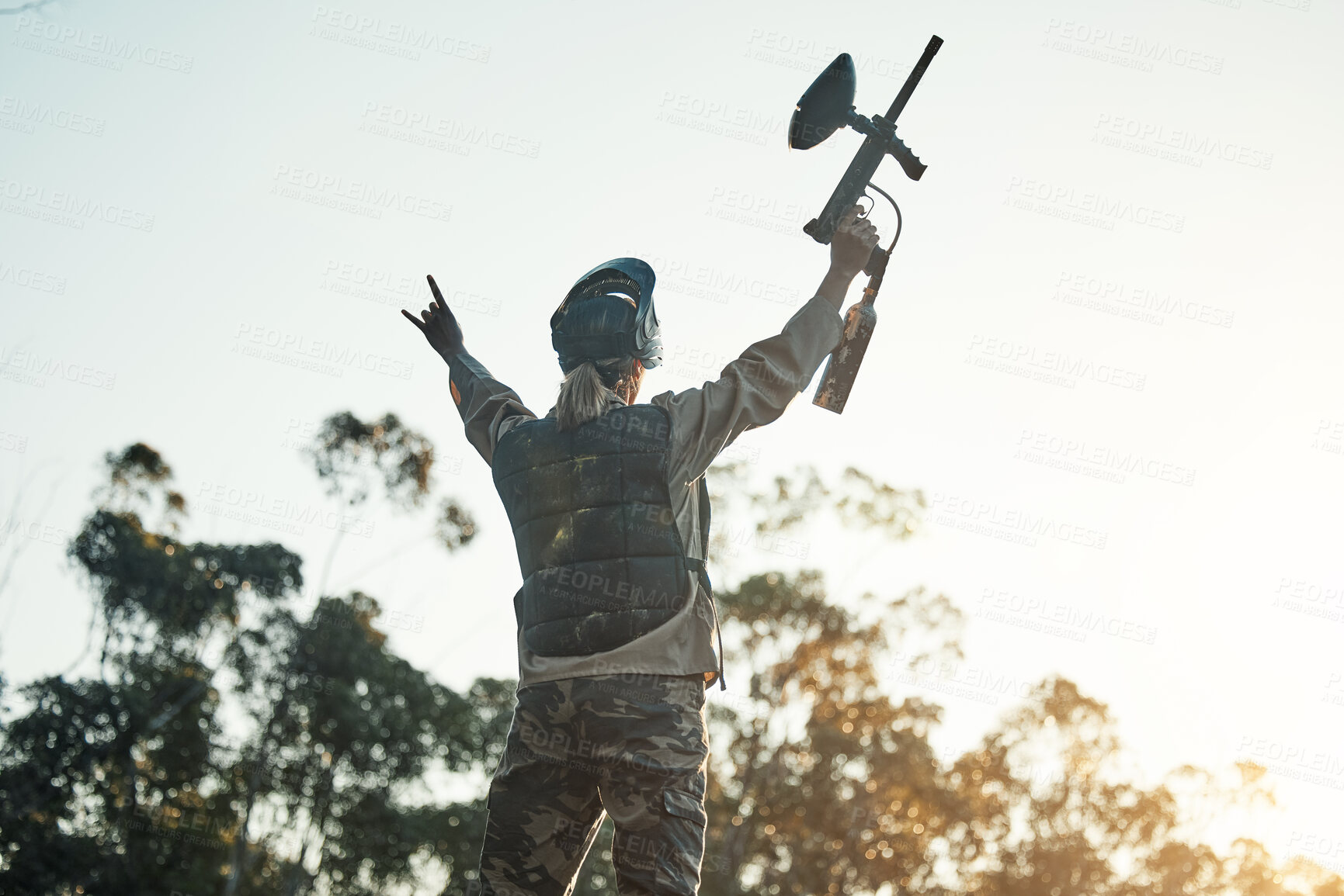 Buy stock photo Paintball game, victory and woman celebration, cheers or excited for battlefield success, army training event or achievement. Fun mission winner, nature sky and back of person with competition win