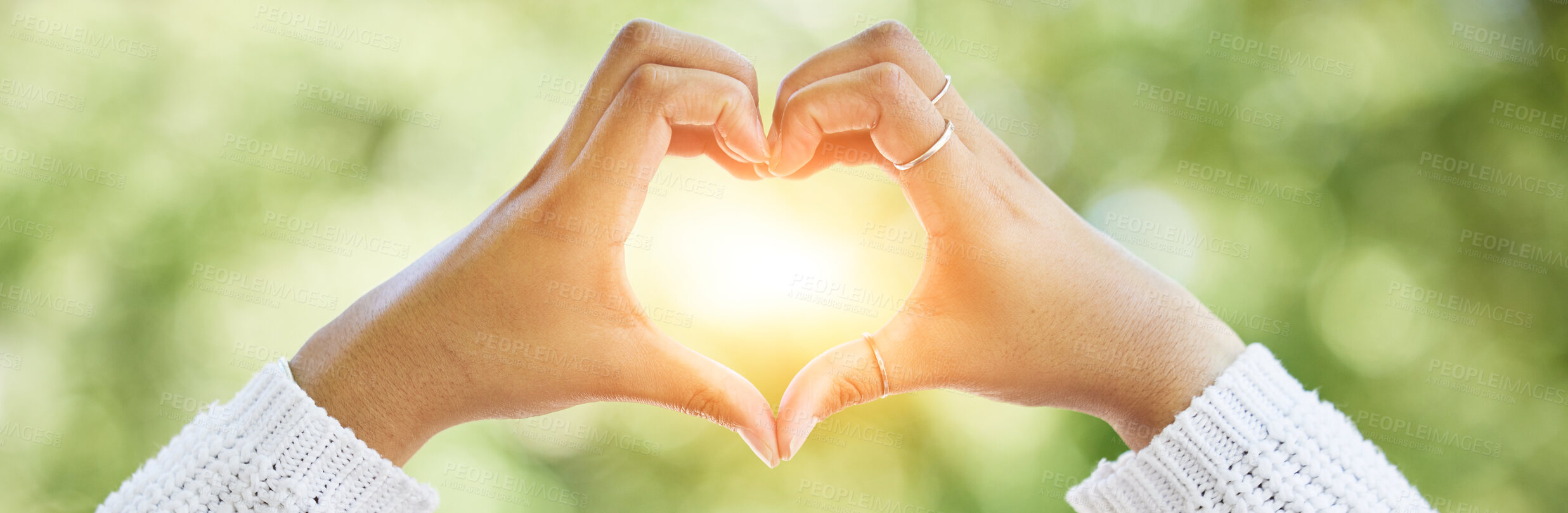 Buy stock photo Love, heart and lens flare with hands of woman in nature for support, motivation and kindness. Thank you, peace and hope with closeup of person and sign in outdoors for emoji, health and banner