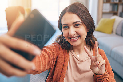 Buy stock photo Face, woman and peace for selfie with smile in home while live streaming on video call in living room. Profile picture, happy female gen z and show v sign, hand emoji and memory for social media post